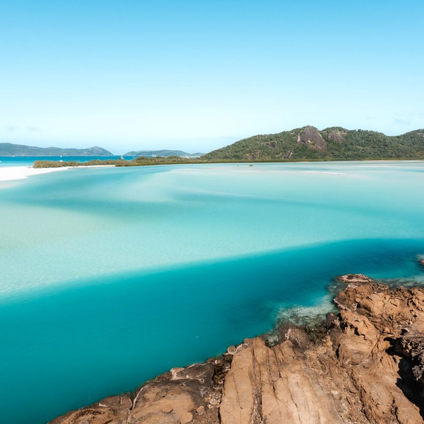 vibrant blue ocean inlet with rocky shore